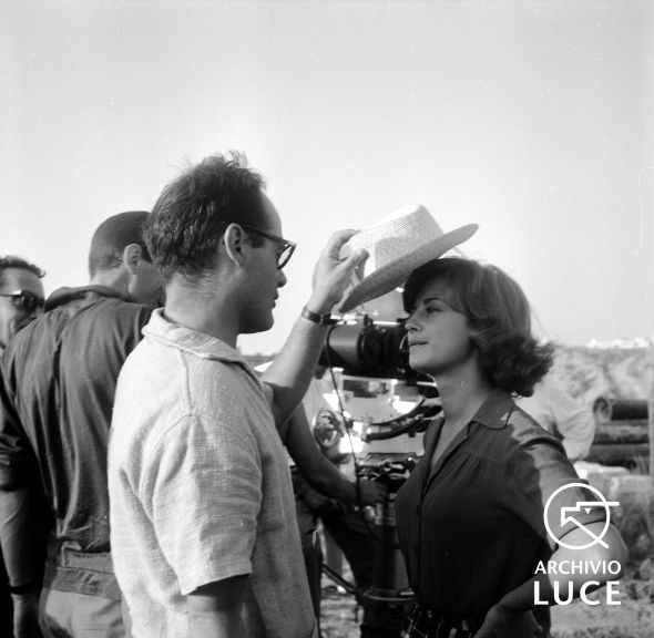 Sul set de Il gobbo un uomo della troupe cala sulla testa di Anna Maria Ferrero un cappello da uomo di paglia, 1960