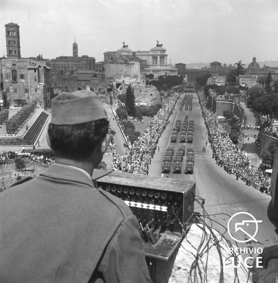 Militare, con apparecchiatura radio, dall'alto del Colosseo controlla lo svolgersi della parata del 2 giugno, 1954