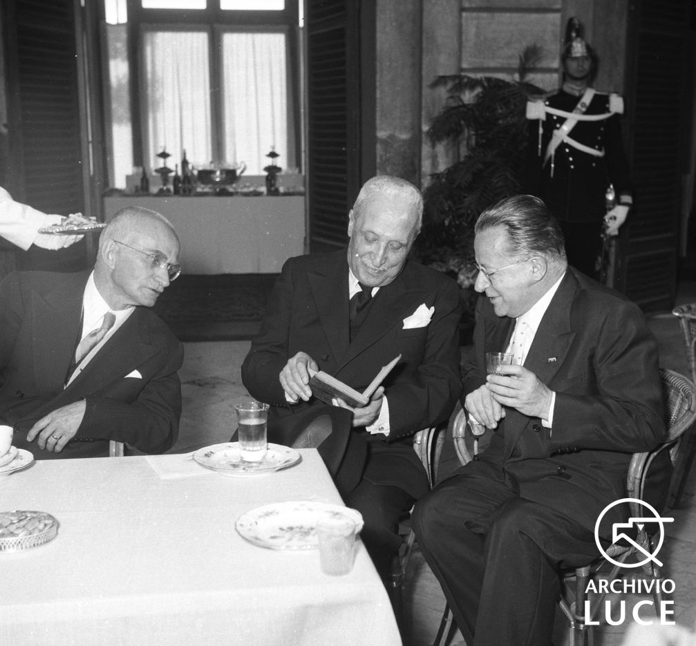 Einaudi seduto ad un tavolo durante il ricevimento per la festa della Repubblicacon Togliatti e De Nicola, 1954